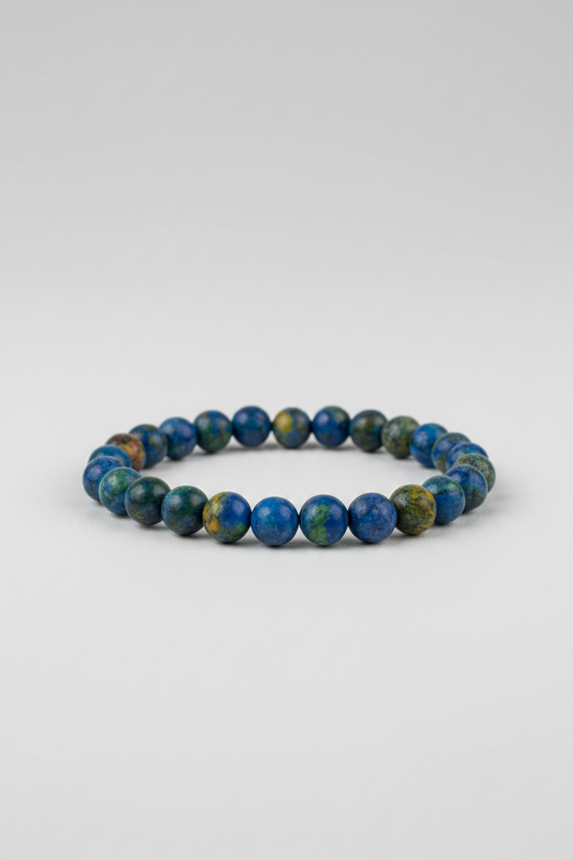 A Phoenix Pine stone bracelet displayed on a wooden surface, with the brand logo &